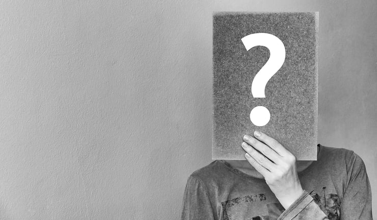 photo of a man holding a question mark in front of his face